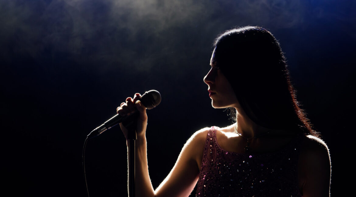 portrait beautiful singing woman dark background